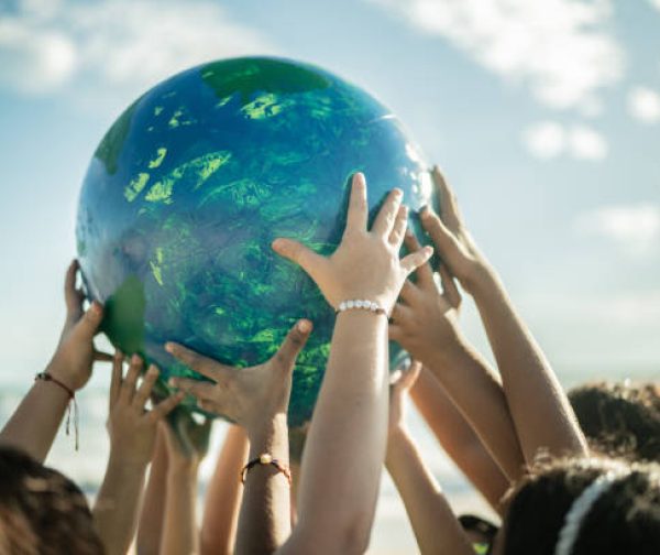 Close-up of children holding a planet at the beach